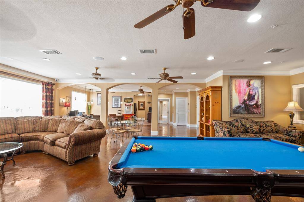 Spacious game room with a pool table, large sectional sofa, and dining area. Amenities are easily accessible.