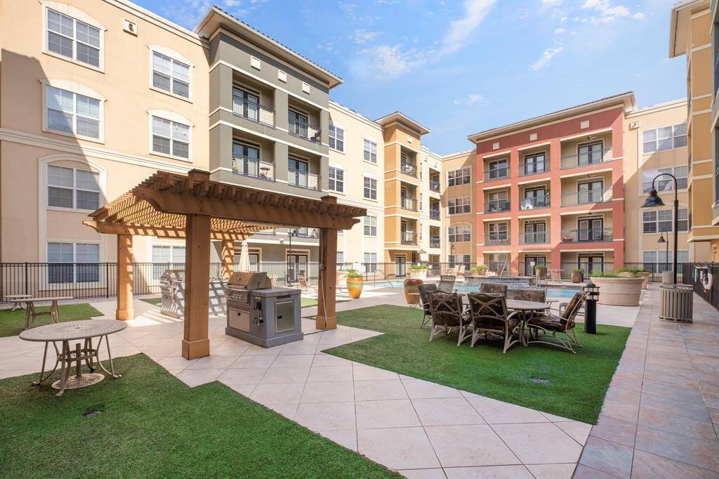 Courtyard features a pergola with a built-in grill, seating areas, and a swimming pool, providing an inviting space for entertainment.