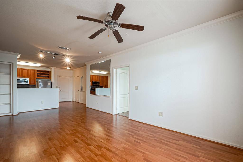The space features an adjoining kitchen with stainless steel appliances and wooden cabinets, providing a modern feel. Split roommate floor plan.