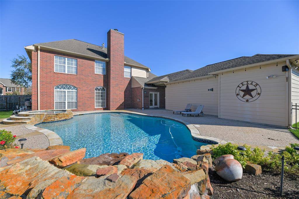 Step out the French doors in the breakfast room to this private backyard paradise with an extra large pool with a brand new pool heater, a rock spillover, and a circular hot tub - all surrounded by stunning landscaping maintained by an in-ground sprinkler system.