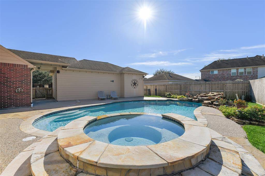 Step out the French doors in the breakfast room to this private backyard paradise with an extra large pool with a brand new pool heater, a rock spillover, and a circular hot tub - all surrounded by stunning landscaping maintained by an in-ground sprinkler system.