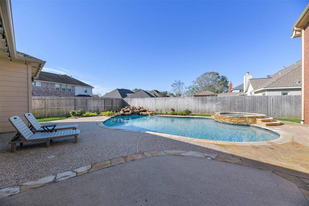 Step out the French doors in the breakfast room to this private backyard paradise with an extra large pool with a brand new pool heater, a rock spillover, and a circular hot tub - all surrounded by stunning landscaping maintained by an in-ground sprinkler system.