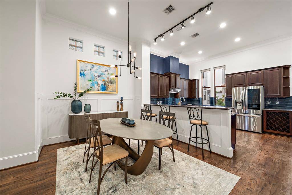 The dining area anchors the main level with wainscoting details and hardwood floors that add character. Its central placement makes it easy to transition from prep to plate, whether you’re hosting or enjoying a quiet night in.