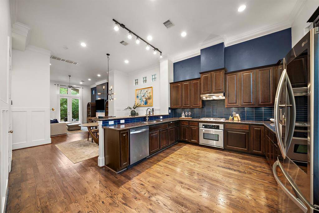 This open-concept kitchen seamlessly connects to the dining and living areas, with generous counter space, bar seating, and room for multiple cooks at once—all designed with both form and function in mind.