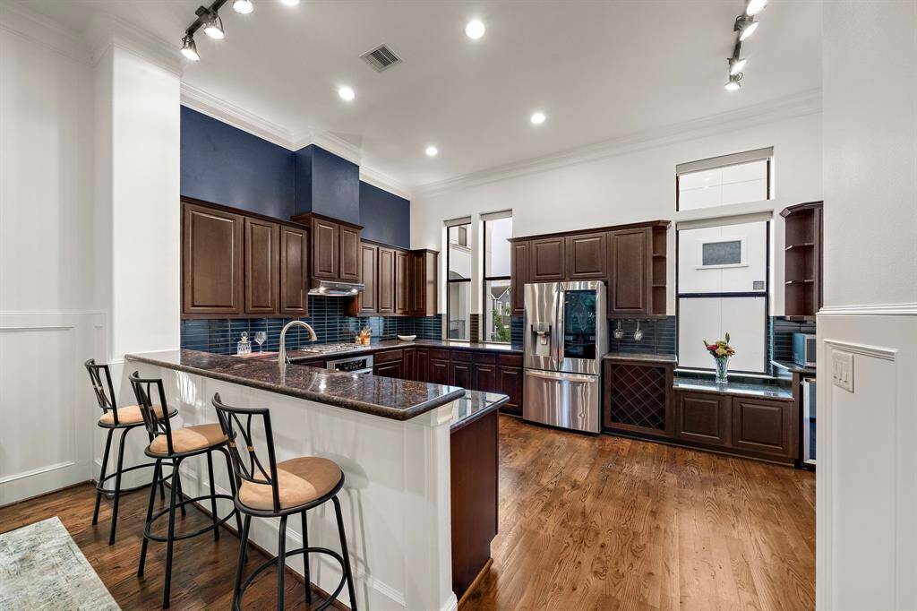 A built-in wine rack, stainless steel appliances, and expansive counters offer everyday convenience with an elevated look. The peninsula provides extra prep space and casual seating for laid-back breakfasts or conversation while cooking.