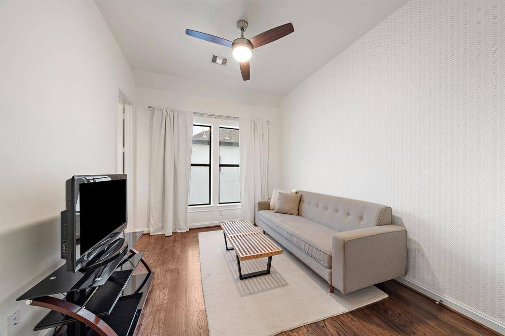 This upstairs bonus space offers flexibility to fit your needs—perfect as a home office, workout room, or cozy media den, with wood flooring and soft natural light enhancing the comfort.