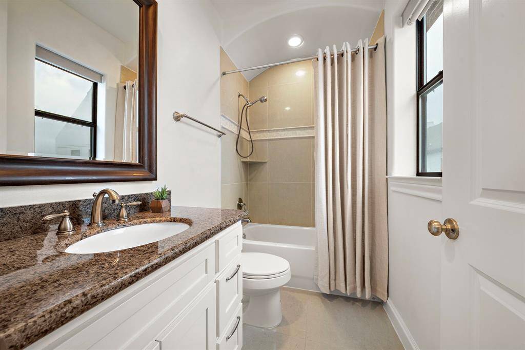 Serving the adjacent bedroom or flex area, this full bath includes a granite-topped vanity, tile-surround tub/shower combo, and window for added light and ventilation.
