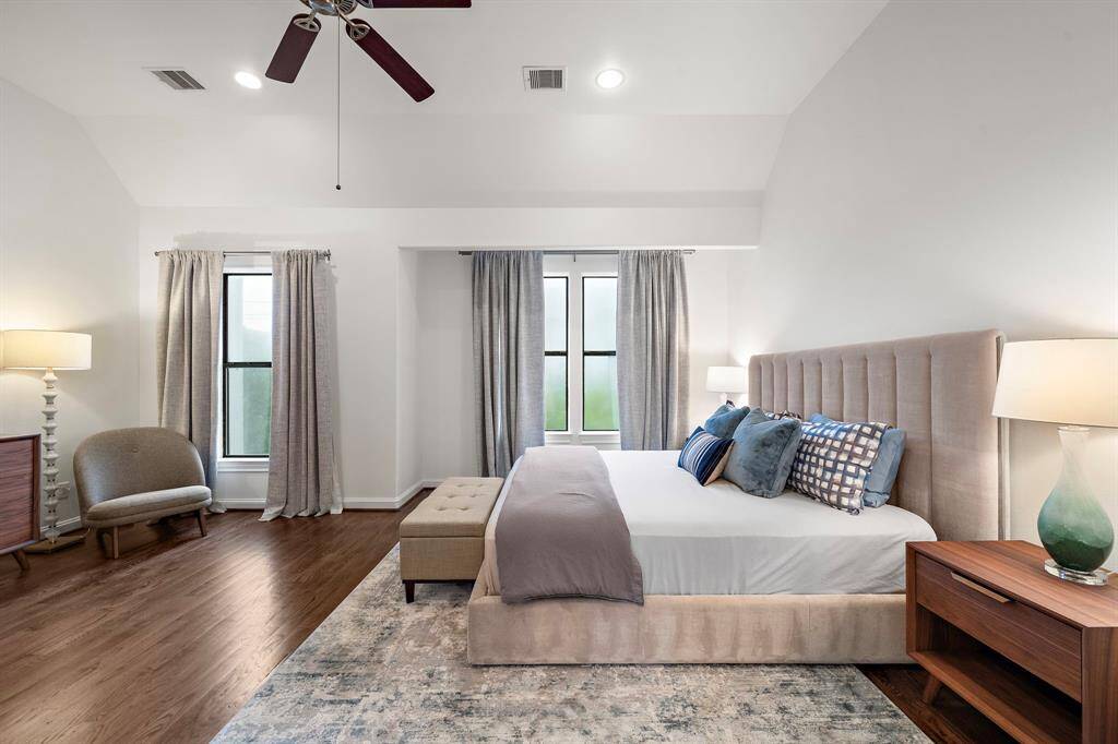 The upstairs primary retreat offers a calming atmosphere with high ceilings, soft light, and space for a cozy reading nook or lounge area. A large walk-in closet with custom storage completes the suite’s everyday livability.