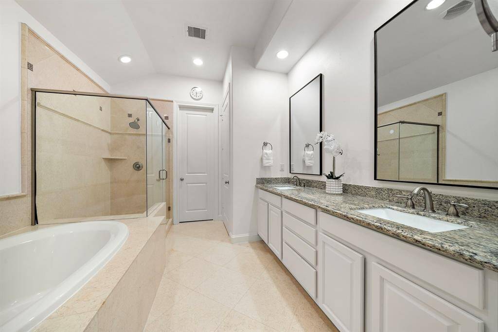 Thoughtfully designed for comfort, the spa-like primary ensuite bath features dual vanities, a soaking tub, and a walk-in glass shower with neutral tile finishes. Subtle luxury meets practicality in a space that feels both stylish and serene.