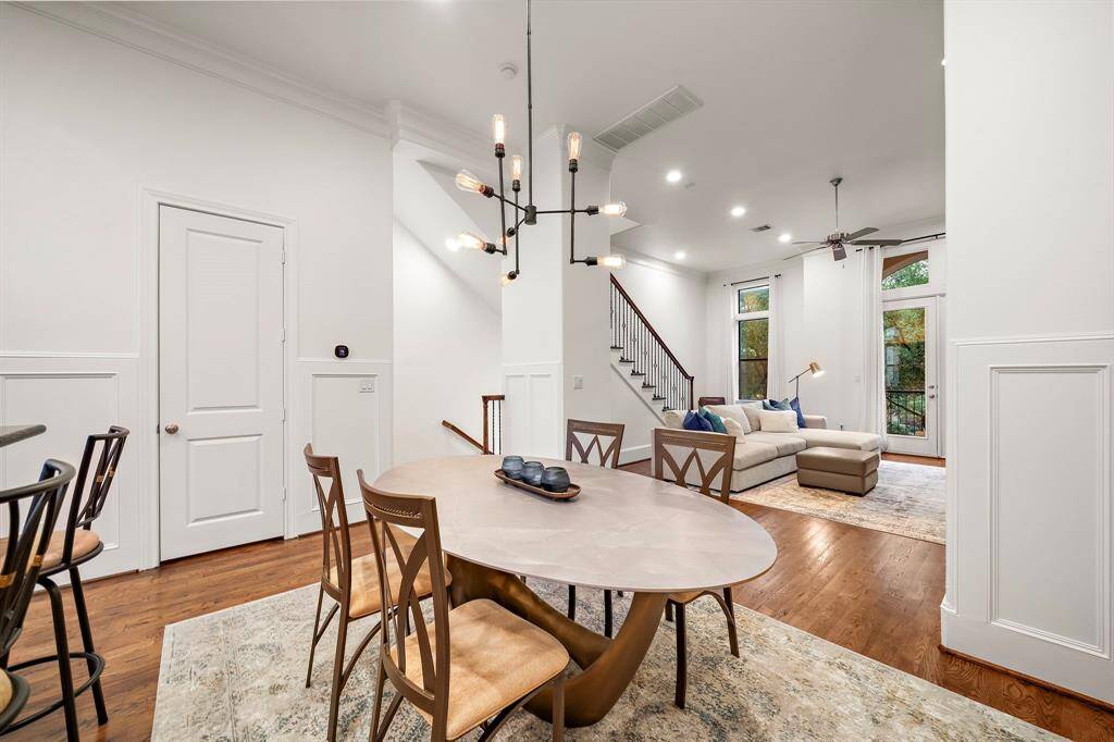 The dining area offers an inviting place to gather, with warm hardwood floors and wall paneling that add character. Its central location between the kitchen and living room makes entertaining feel effortless.