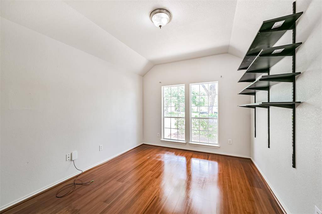 Bright and inviting home office featuring elegant hardwood floors and abundant natural light.