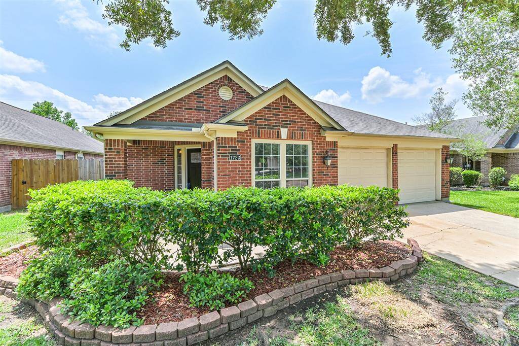 Charming single-story brick home with a welcoming front porch,