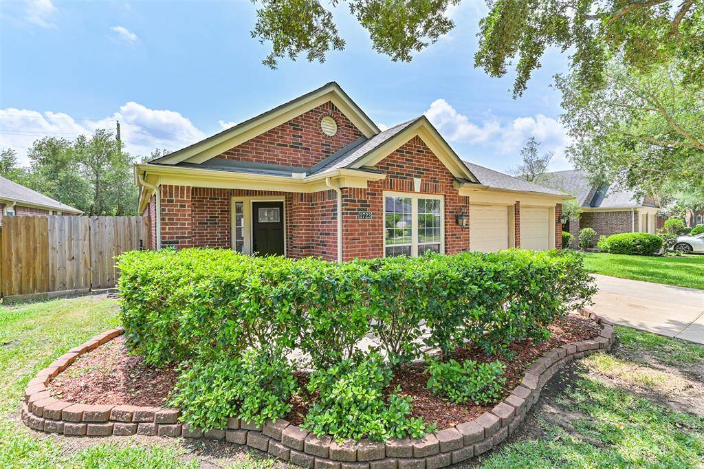 Charming brick home with a welcoming front porch. It features a well-maintained lawn and is surrounded by trees, offering a cozy and inviting curb appeal.