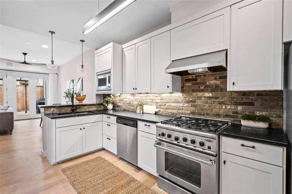 [Kitchen]Impressive kitchen is designed for functionality and beauty appointed with soapstone countertops and rustic brick backsplash