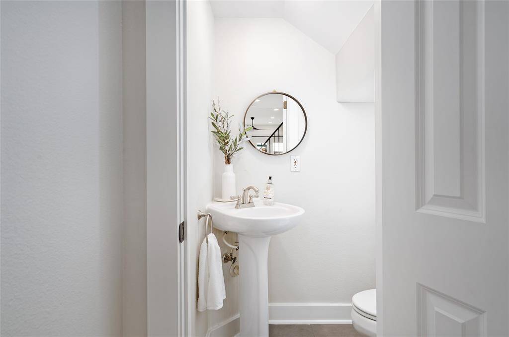 [1st Floor Powder Room] half bath discreetly located under the stairs