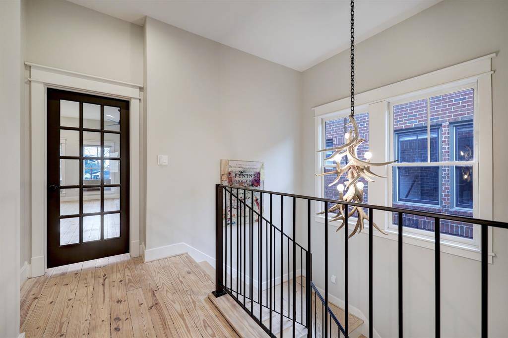 [2nd story landing] alternate view, notice the french door framed by elegant word work, leading to Primary Bedroom