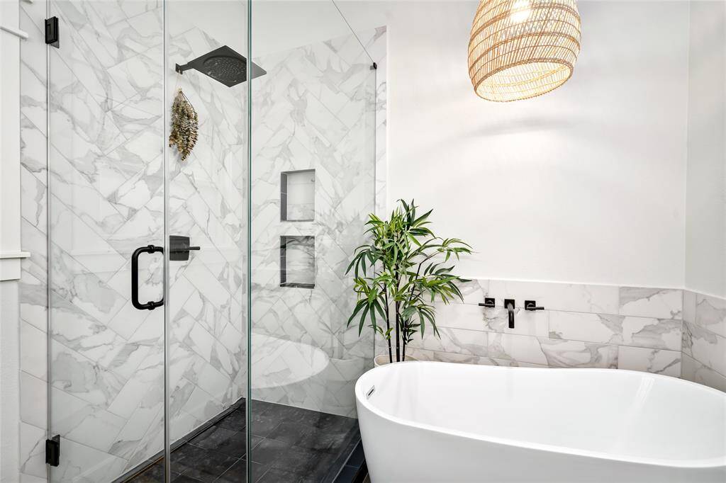 [Primary Bath]Carrara marble tile surround, bespoke pendant light and soaking tub create a spa like ambience