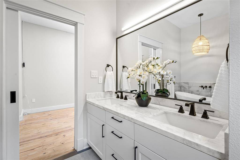 [Primary Bath]Well appointed with double vanity, bronze hardware and iron mirror, curated for a vintage inspired style