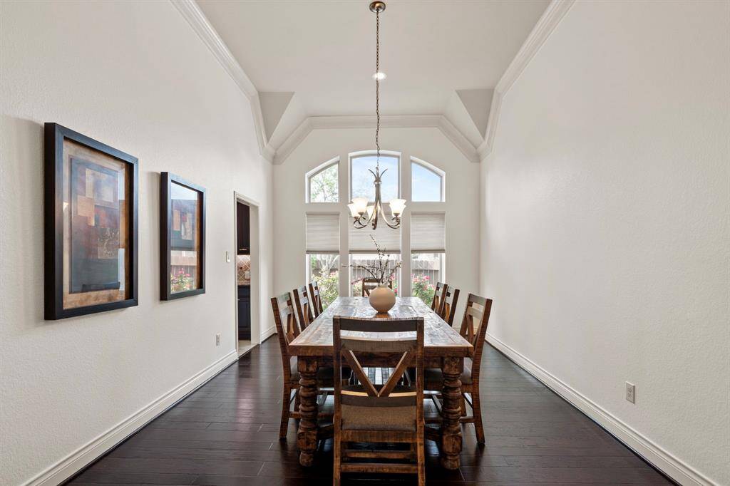 A wall of picture windows bathes the formal dining room in natural light, accentuating the vaulted ceiling and providing a scenic backdrop for every meal.