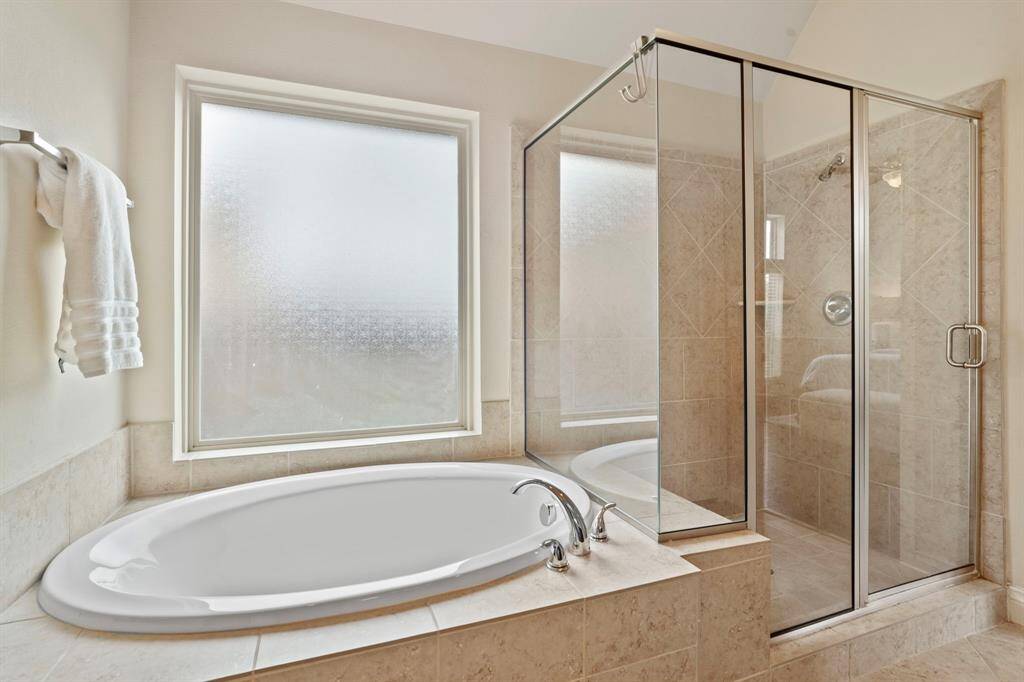 Pamper yourself in the oversized soaking tub or step into the fully tiled glass-enclosed shower—your spa day begins at home.