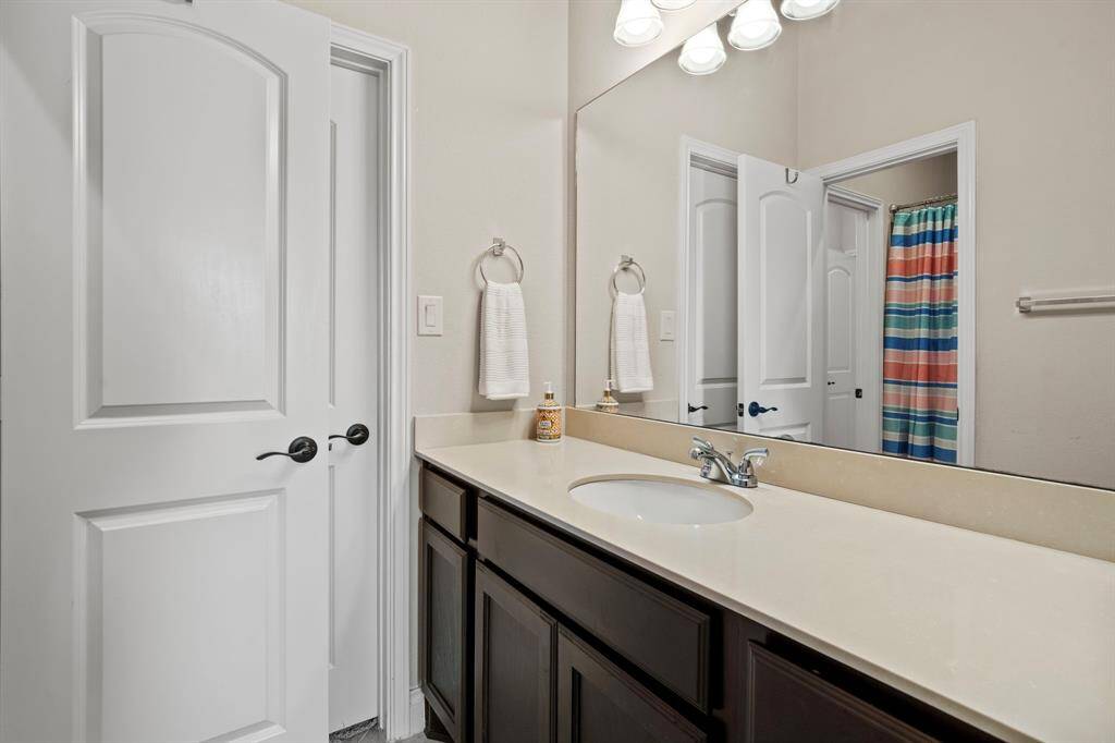 The third bedroom offers private access to a shared bathroom with an extended vanity, plenty of counter space, and a walk-in closet.