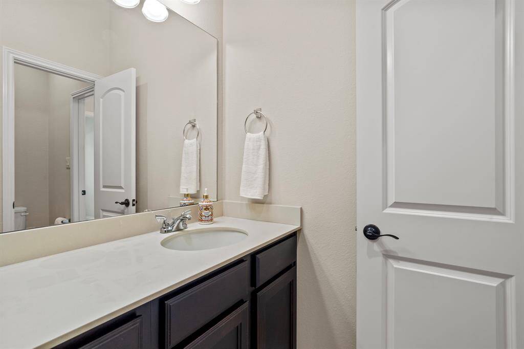 A second vanity on the opposite side of the bathroom connects to the hallway, adding extra functionality and convenience.