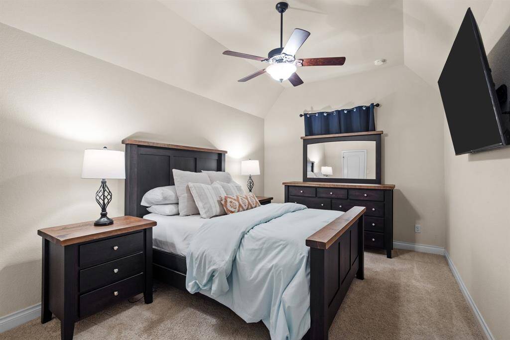 This inviting fourth bedroom offers plush carpet, high ceilings, and a walk-in closet, with convenient access to the nearby shared bathroom.