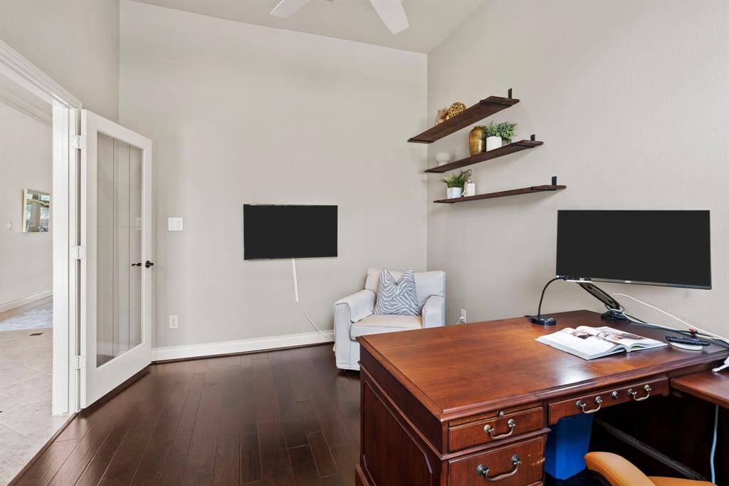 Just off the foyer, this dedicated home office features rich wood flooring, French doors, and built-in shelves—an ideal space for focused work or creative pursuits.