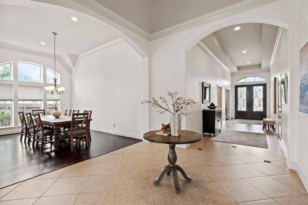 The extended foyer sets an elegant tone with its soaring tray ceiling, and graceful archways leading into the formal spaces and beyond.