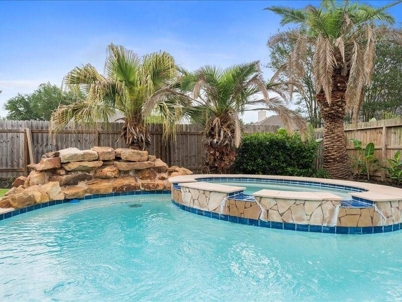 Sparkling Pool with Hot Tub Jacuzzi and Rock Waterfall.