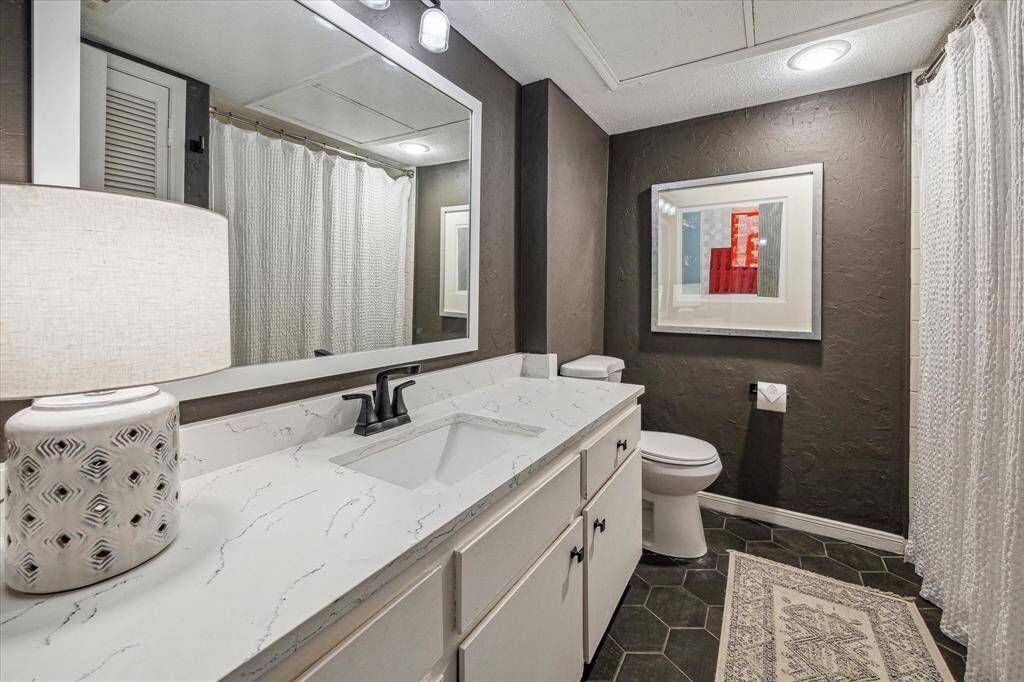 The secondary bathroom features stylish new hexagonal tile, a shower/tub combo, under sink storage, and also serves as the guest bath.