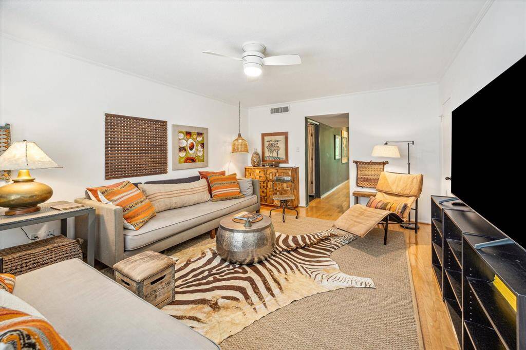 As you step inside, you are greeted by a spacious living room. Featuring a ceiling fan, crown molding, a closet with shelving.