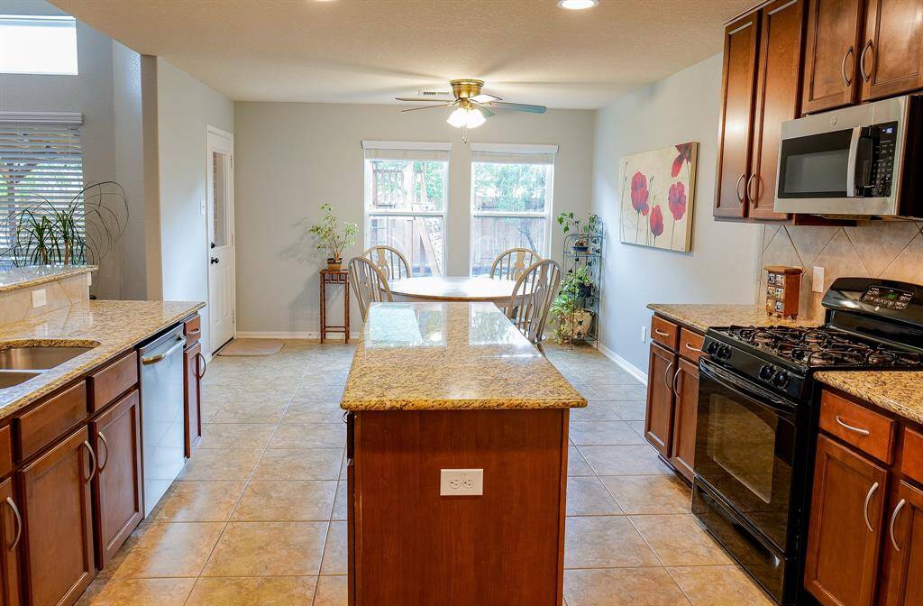 The kitchen is complete with center island, granite counters and gas cooktop.