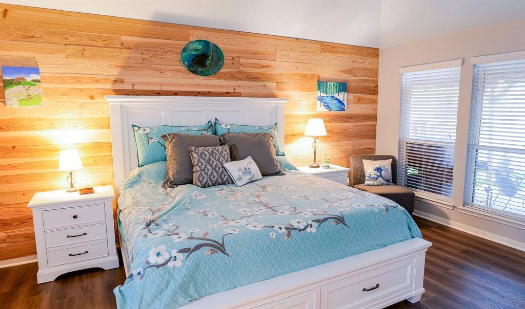 Primary bedroom, with a custom wood plank wall, adds a touch of warmth to the space.