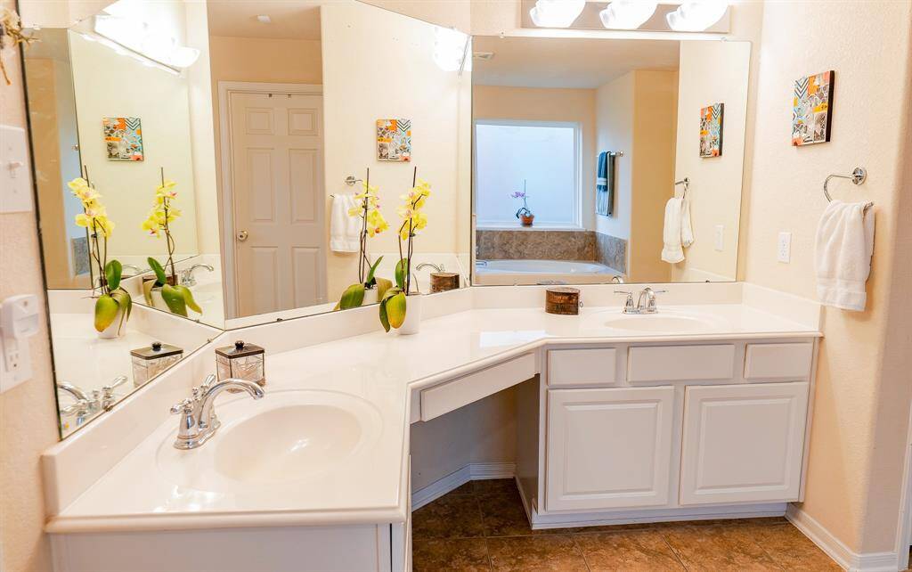 The primary bathroom has separate sink areas and a vanity space.