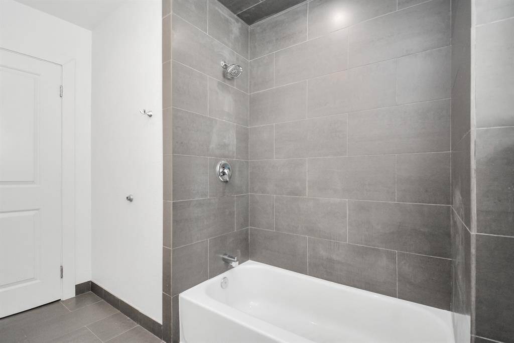 Stylish grey accents and tile floors in the bathroom and a tub/shower combo