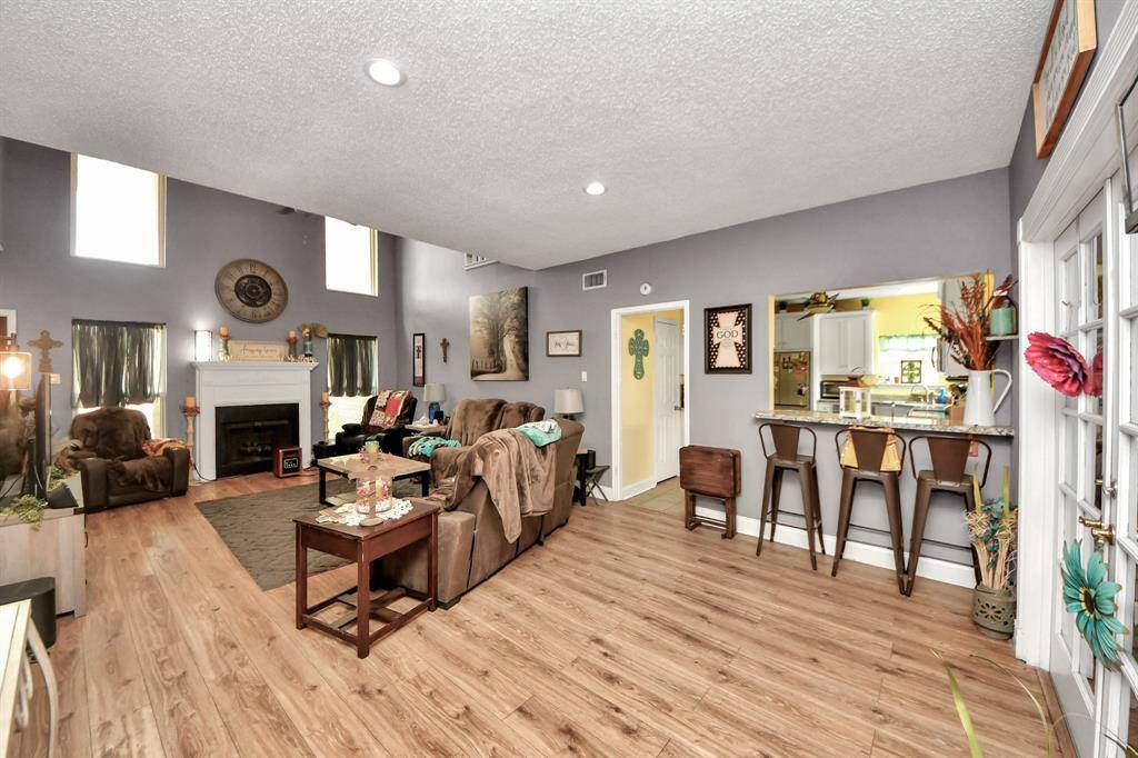 The open layout includes a comfortable seating area and a breakfast bar connecting to the kitchen, perfect for entertaining.