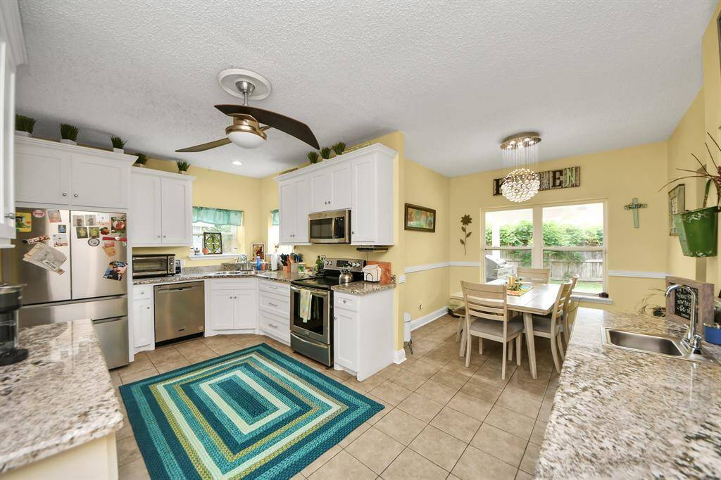 An inviting dining area with large windows offers views of the backyard.
