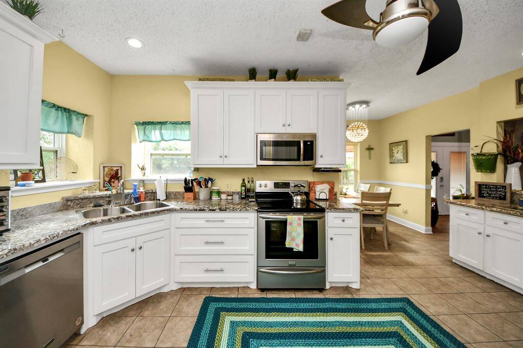 Charming corner sink with serene backyard views, complemented by spacious slide-out cabinet drawers for effortless storage.
