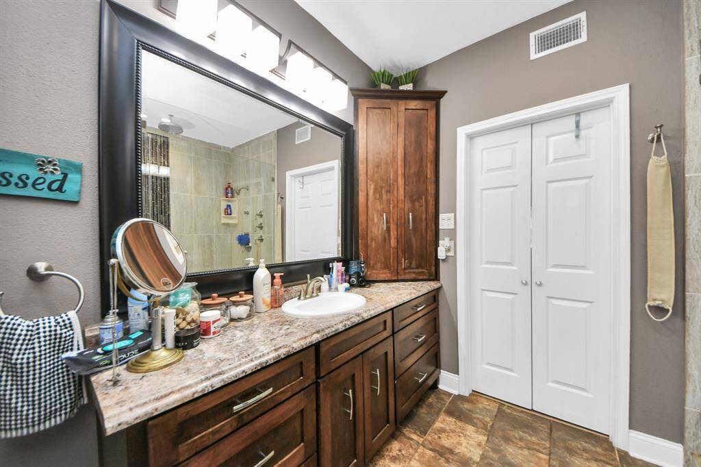 The primary bathroom boasts beautiful granite surfaces and plenty of storage space for all your essentials.