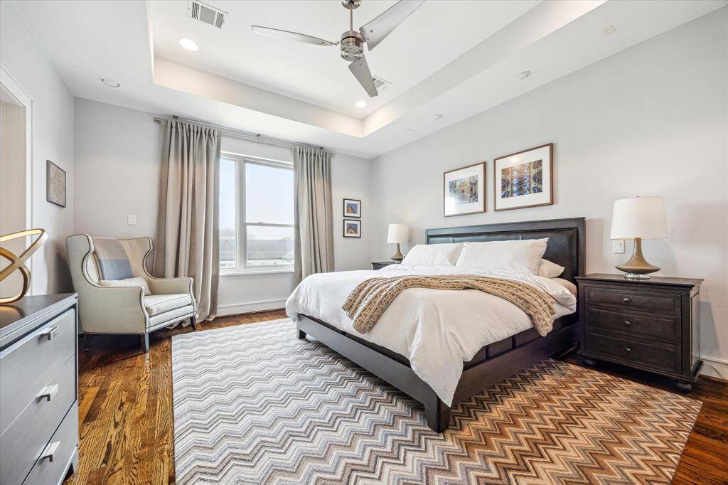 Huge primary bedroom, also with gleaming hardwoods, contemporary ceiling fan, recessed lighting and custom curtains.