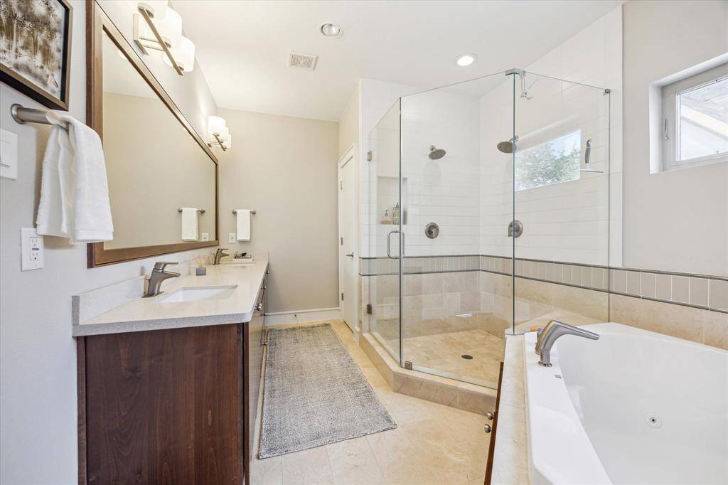 Luxurious primary bath with oversized shower and jetted tub. Double sinks and richly appointed fixtures and hardware.