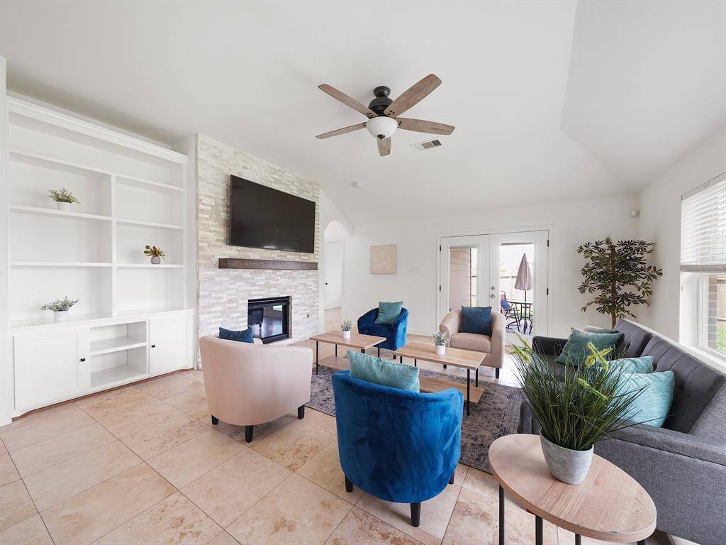 Family room features gas fireplace built in shelving, natural light and view of the covered patio