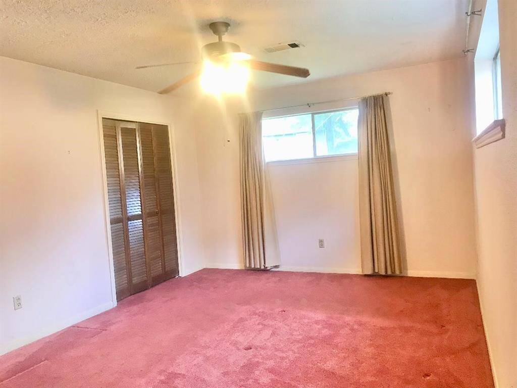 View into the 1st floor  primary suite with walk in closet from the connecting bath rm