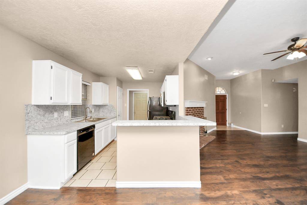 Open kitchen and living area that features granite countertops, and stainless steel appliances.