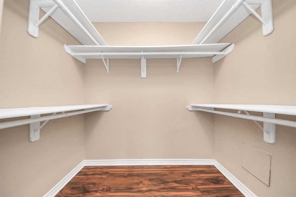 Effortless organization in a spacious and beautifully arranged primary closet.