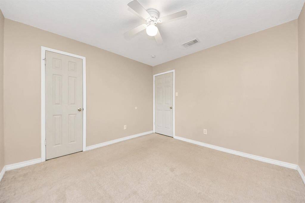 This thoughtfully designed secondary bedroom provides a comfortable, welcoming environment.