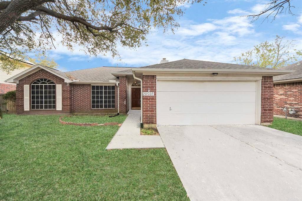 Charming single-story brick home with a two-car garage and a well-maintained front lawn.