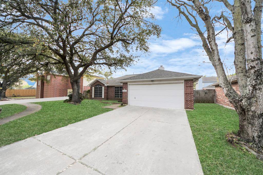 Spacious front yard with a concrete driveway and a welcoming entrance.