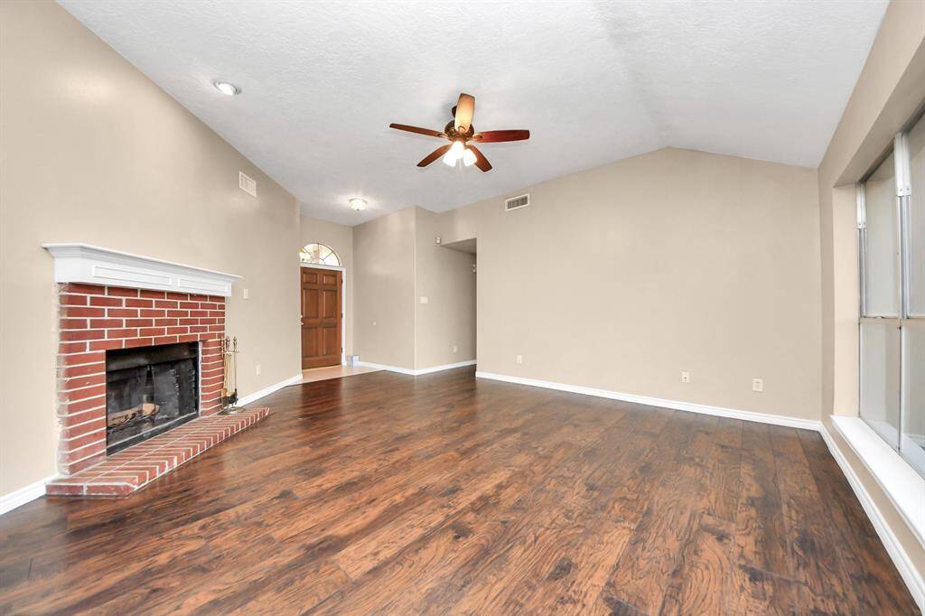 Spacious living space with a timeless brick fireplace.